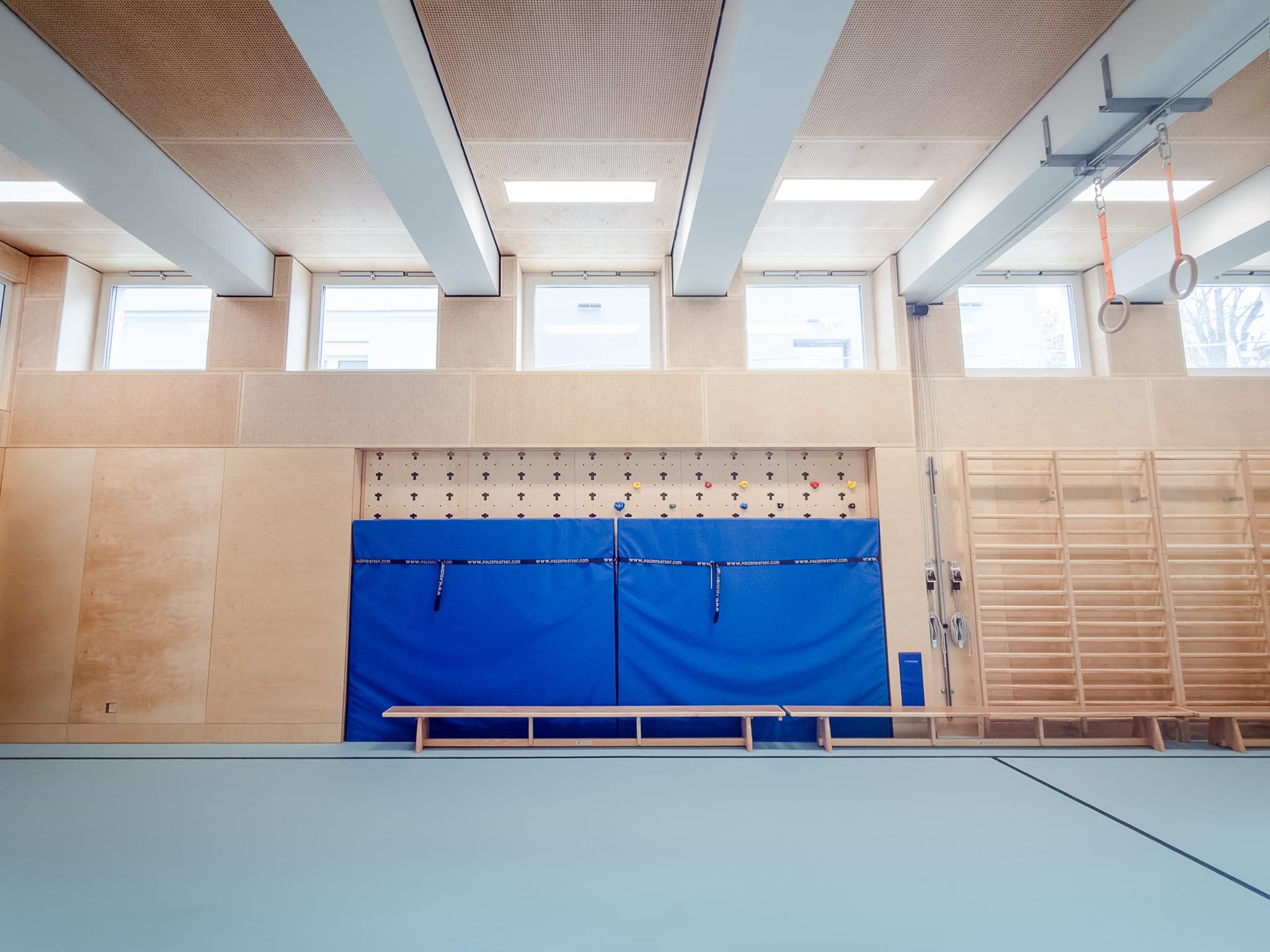 Sportsaal ALL IN mit Sprossenwand und blauen Matten